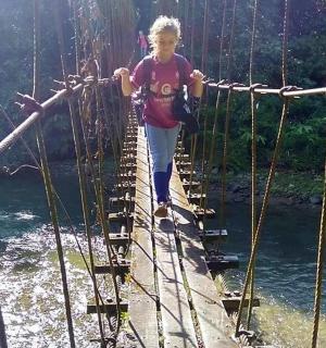 一个小女孩正在穿过河上的吊桥