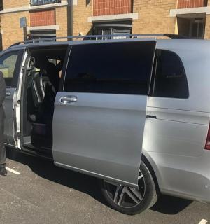 a man in a suit standing next to a van