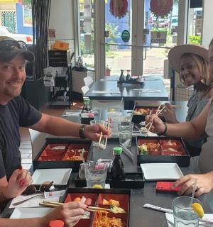 skupina lidí sedících u stolu a jedících