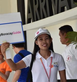 一个女孩在一群人面前举着牌子