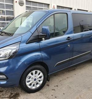 una furgoneta blava aparcada en un aparcament