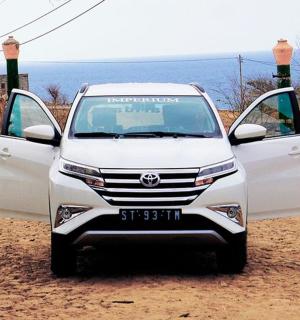 a white car with its doors open on a dirt road