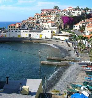 一群船停在海滩边，旁边是一座小镇