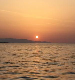 a sunset over the ocean with the sun in the sky