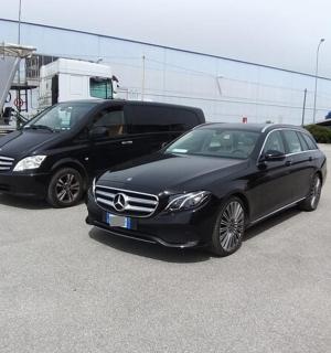 two black cars parked next to a truck