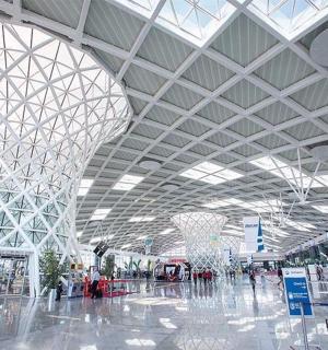 an airport with a large building with a glass ceiling