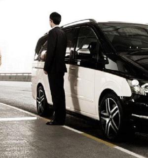 a man standing next to a car parked in a parking lot