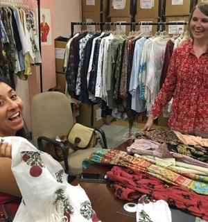 Dvě ženy stojící v obchodě se stolem s oblečením