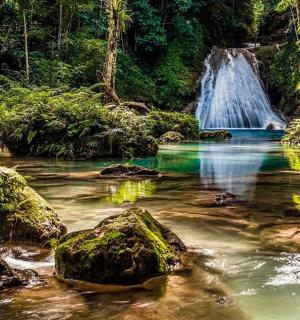 a waterfall in the middle of a river with rocks