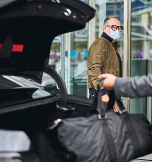 a man wearing a mask standing next to a car