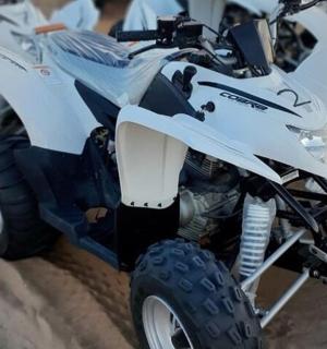 a close up of a white atv parked in the sand