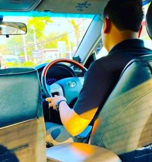 un home conduint un cotxe per la carretera