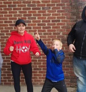 a group of people standing in front of a brick wall