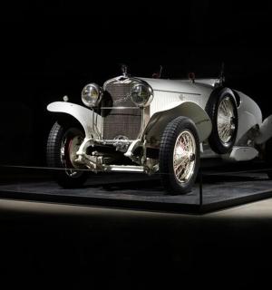 an old white car on display in a dark room