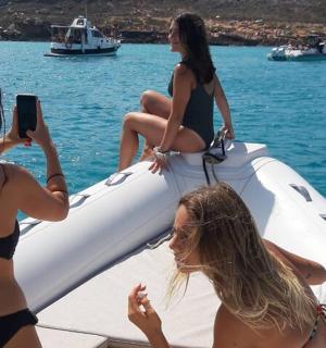 three girls in bathing suits on a boat in the water