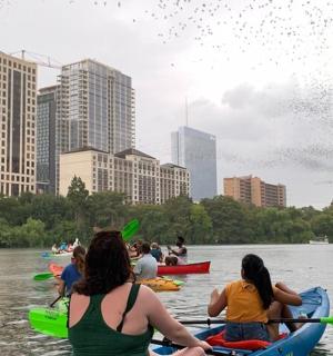 a group of people kayaking on the river in a city