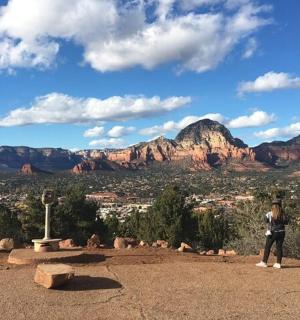 a woman standing in front of a view of the mountains