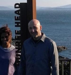 muž a žena stojící vedle oceánu