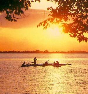 日落时分,一群人在水上的船上