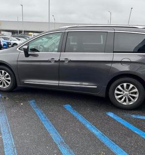 sebuah mobil van berwarna perak diparkir di tempat parkir