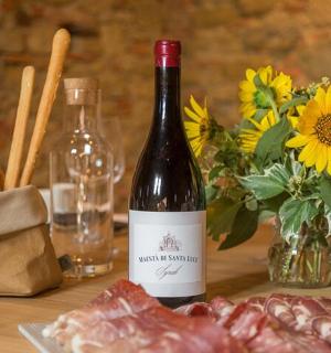 láhev vína na stole s masem a květinami