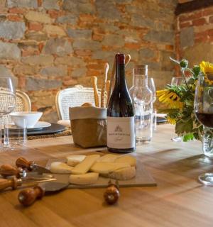 dřevěný stůl s lahví vína a sýrem