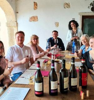 一群人围坐在桌旁，桌上摆满了酒瓶