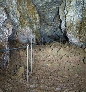 a cave with a fence in the middle of it