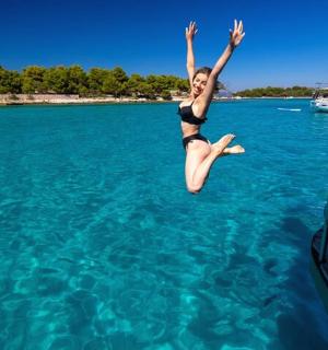 एक महिला पानी में नाव से कूद रही है