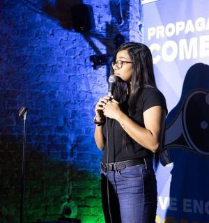 a woman standing on a stage holding a microphone