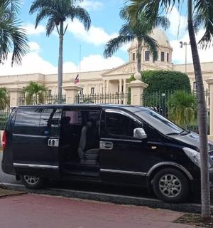 a black van parked in front of a building with palm trees