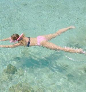 a woman laying in the water with a frisbee