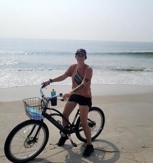 a woman riding a bike on the beach