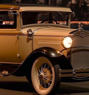 一辆旧车在夜间行驶在街道上