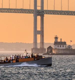 loď s lidmi na ní ve vodě poblíž mostu