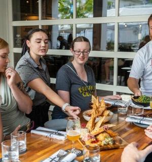 a group of people sitting around a table eating food