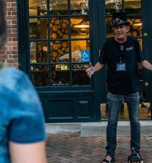 a man wearing a hat standing in front of a store