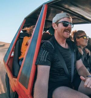 一群人乘坐吉普车在沙漠中行驶