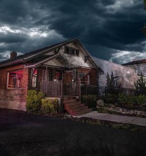 an old brick house with a cloudy sky