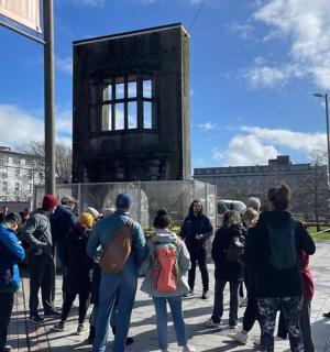 a group of people standing around a clock tower