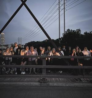 a group of people standing on a bridge