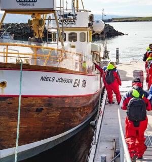 一群人在水中登上一艘船