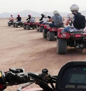 a group of people riding atvs in the desert