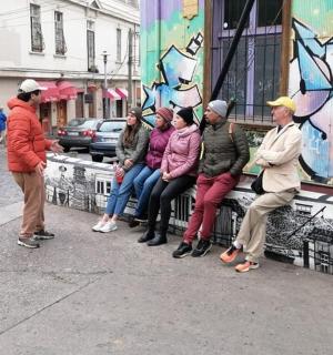 skupina lidí sedících na lavičce na ulici