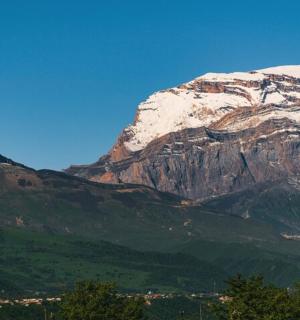 一座白雪皑皑的山峰,山前有一座小镇
