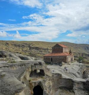 a building on top of a mountain with some rocks