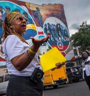 一名女子站在街上,手里拿着相机