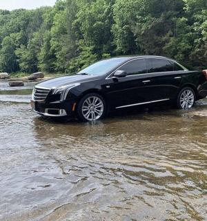 a black car is parked in a river