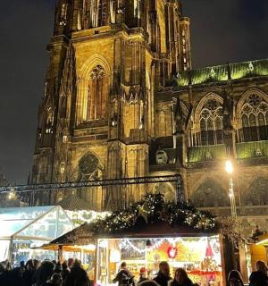 a large building with a clock tower and a christmas market