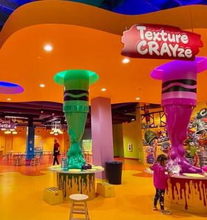 a little girl is standing in front of a exhibit at a theme park